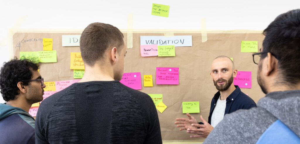 The image shows a group of people in a workshop.